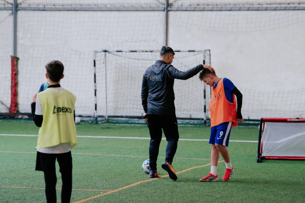Antrenor GOGE încurajând un jucător junior pe teren