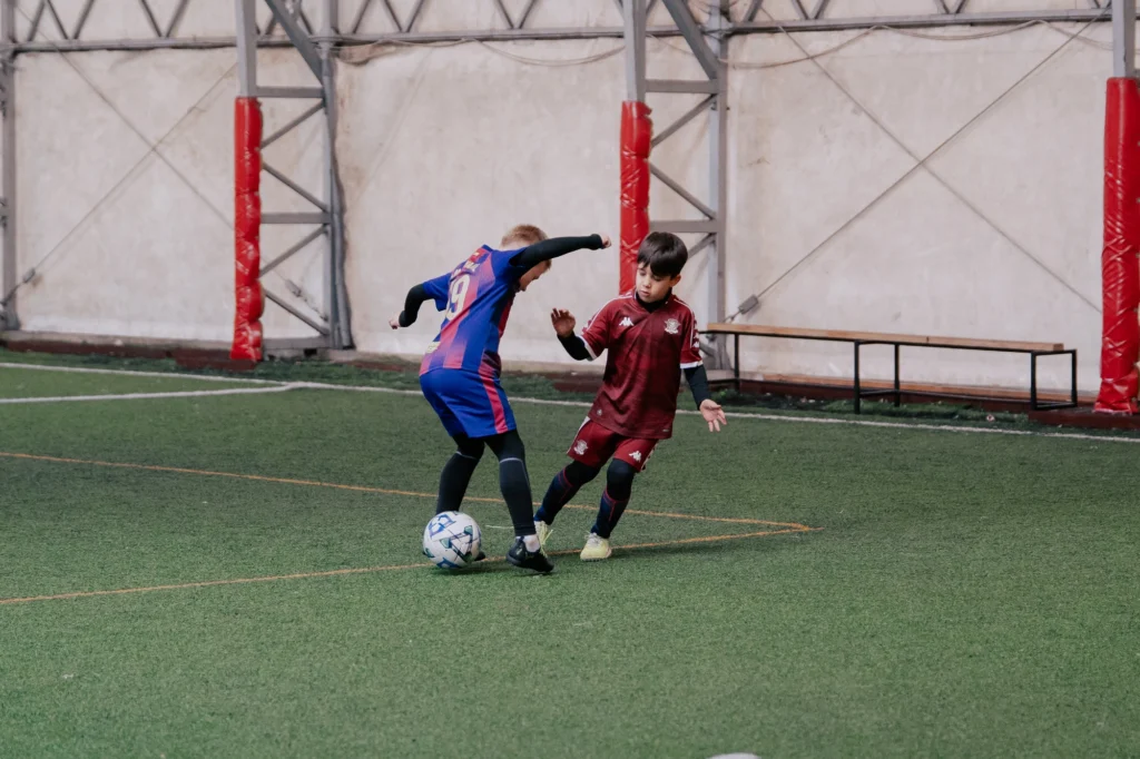 Doi copii într-un duel unu la unu pe terenul de fotbal